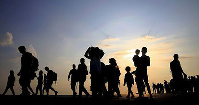 Syrian refugees from Kobani walk at the port of Kos following a rescue opperation off the Greek island of Kos